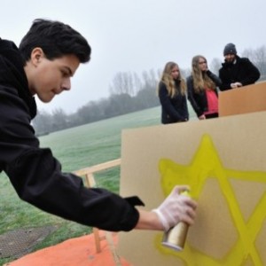 Een jongen maakt een Davidsster van graffiti (beeld: NIOD).